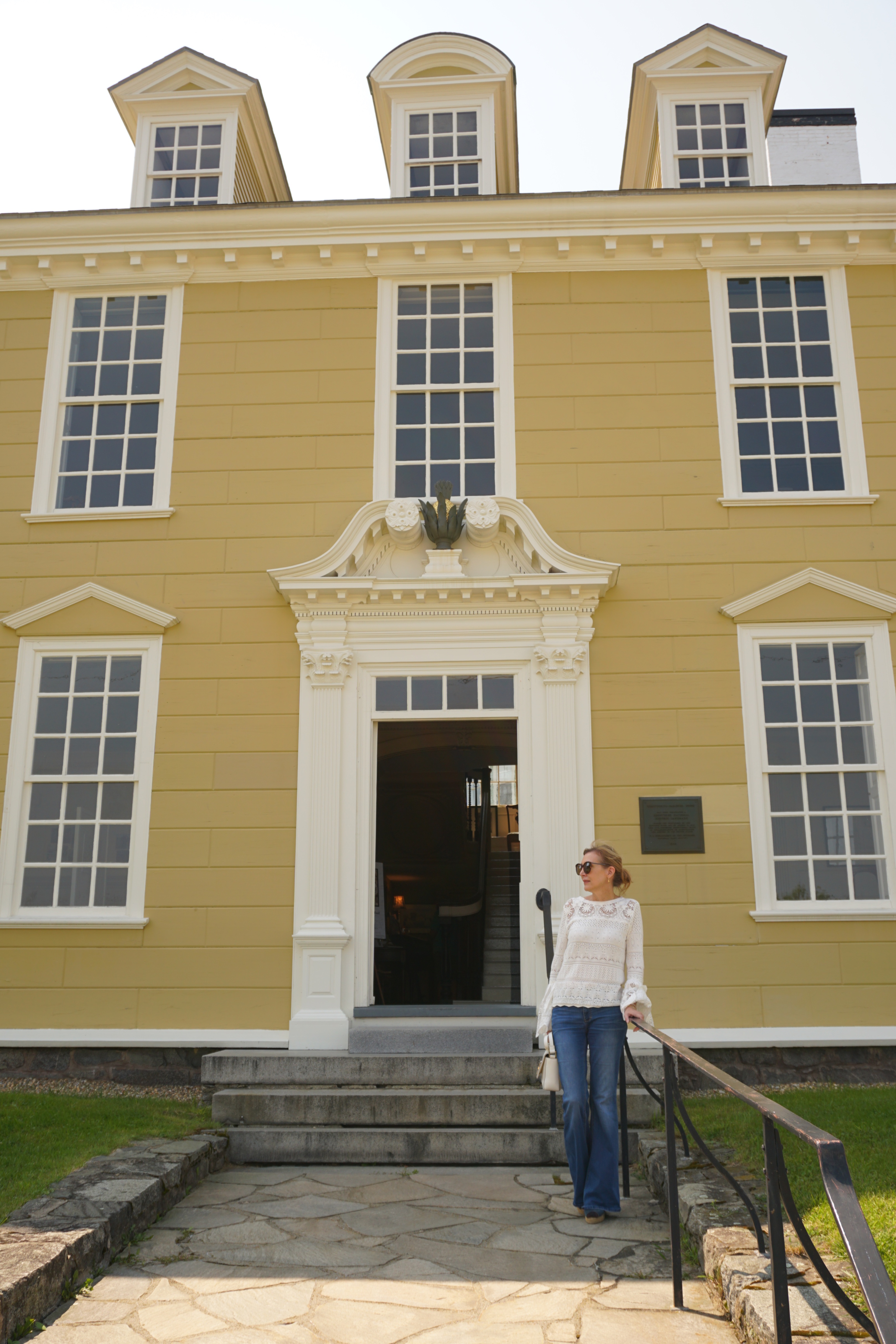 Woman standing in front of historic yellow building