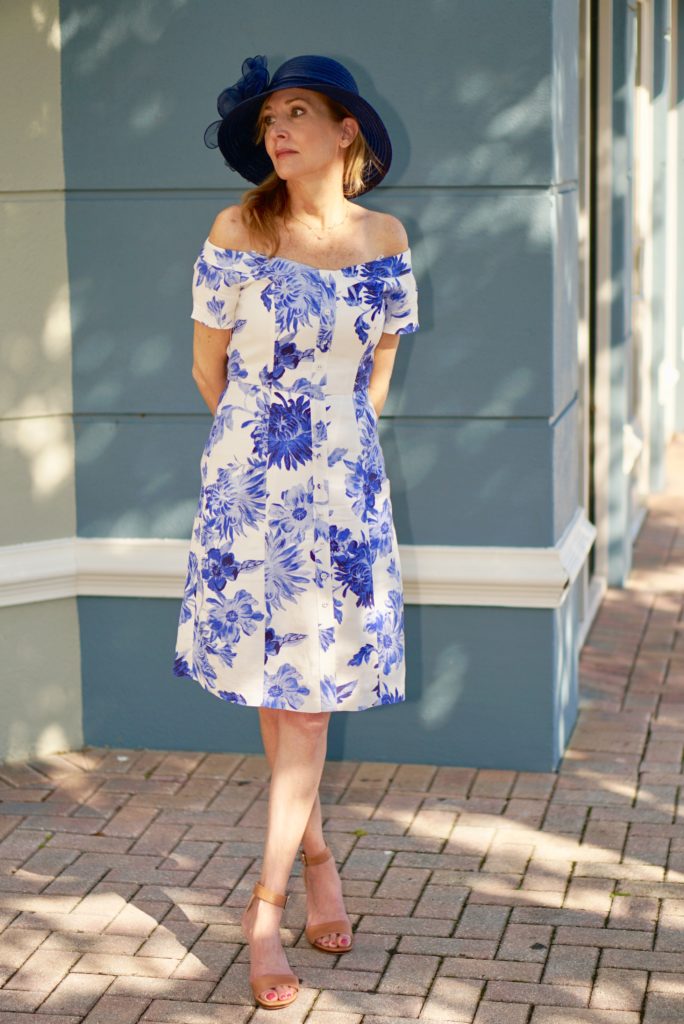 Woman wearing dress with blue flowers and blue fascinator