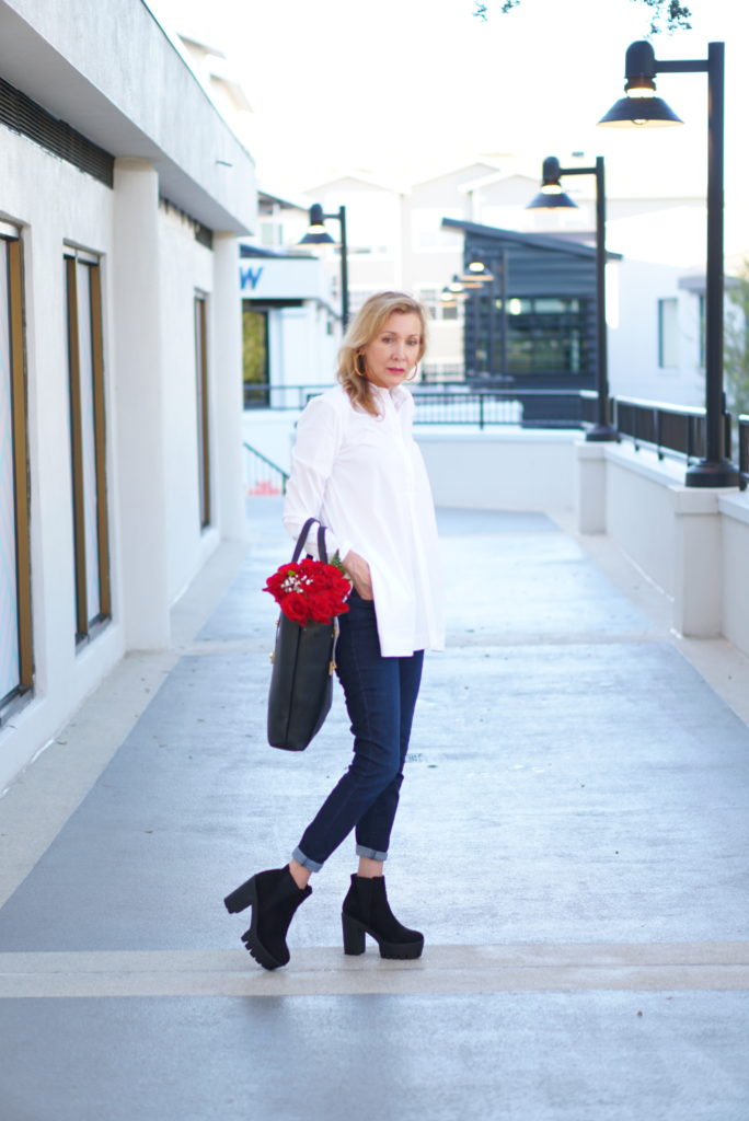 Fall Trends by popular Florida mature fashion blog: image of a woman wearing a white button down blouse skinny jeans, and high heel chelsea boots. 