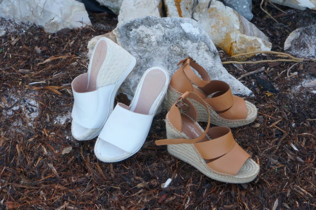 two pairs of sandals next to a rock