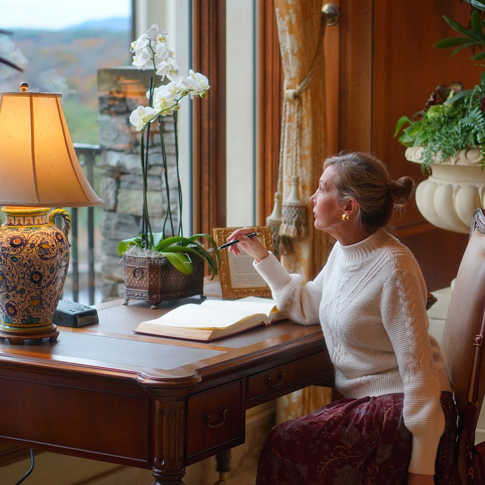 woman sitting at desk looking out a window