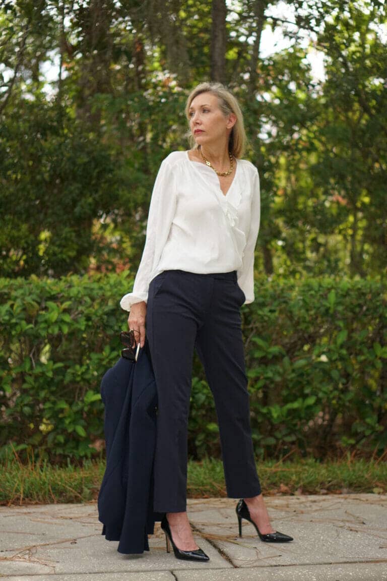 Nina Anders wears navy pants and white top.