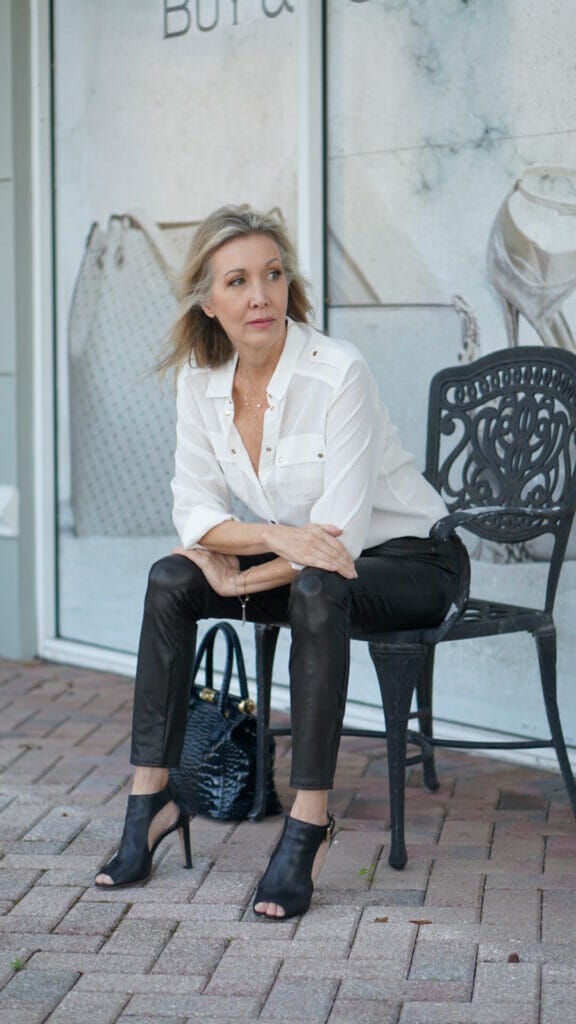 Woman modelling white blouse and black leather pants