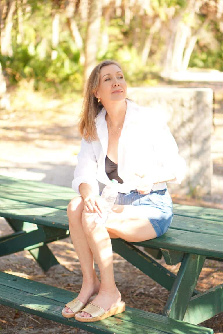 Nina Anders wearing white shirt and jean shorts