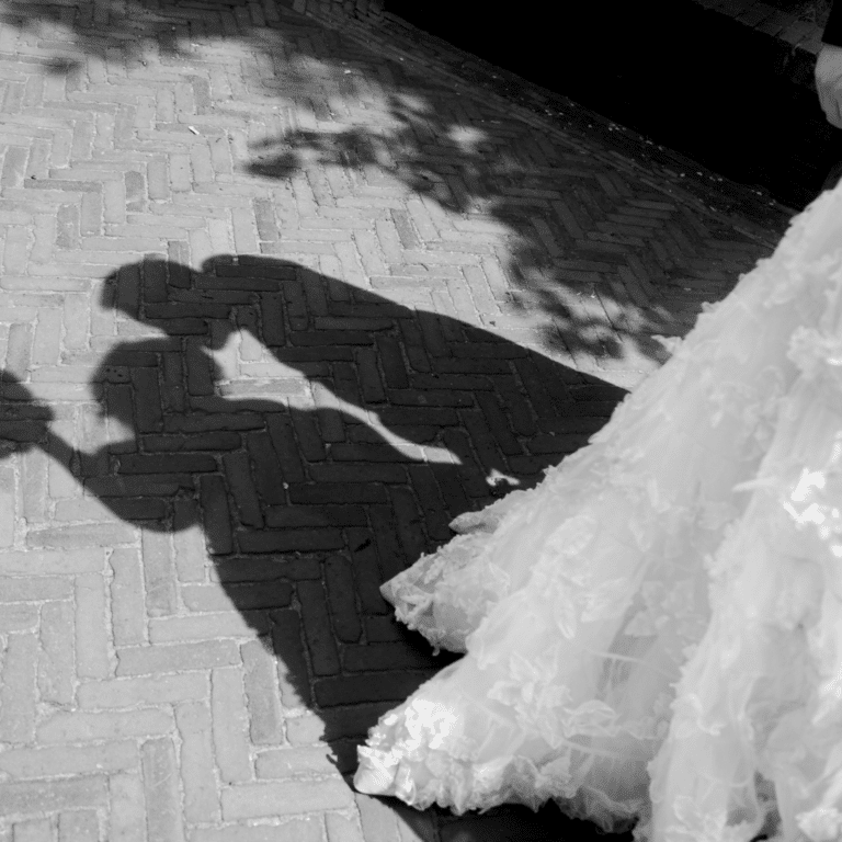 a shadow style photo of man and woman kissing, the edge of the wedding dress is at the right of the photo